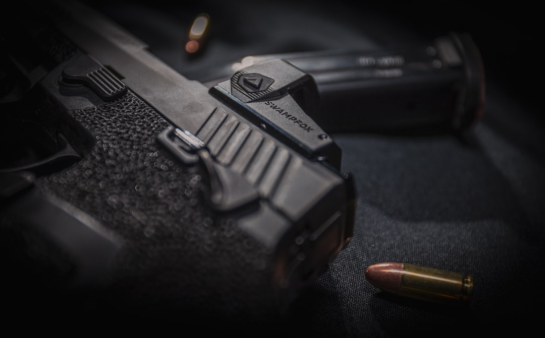 Close-up of a handgun with a conversion kit and a bullet in the foreground.