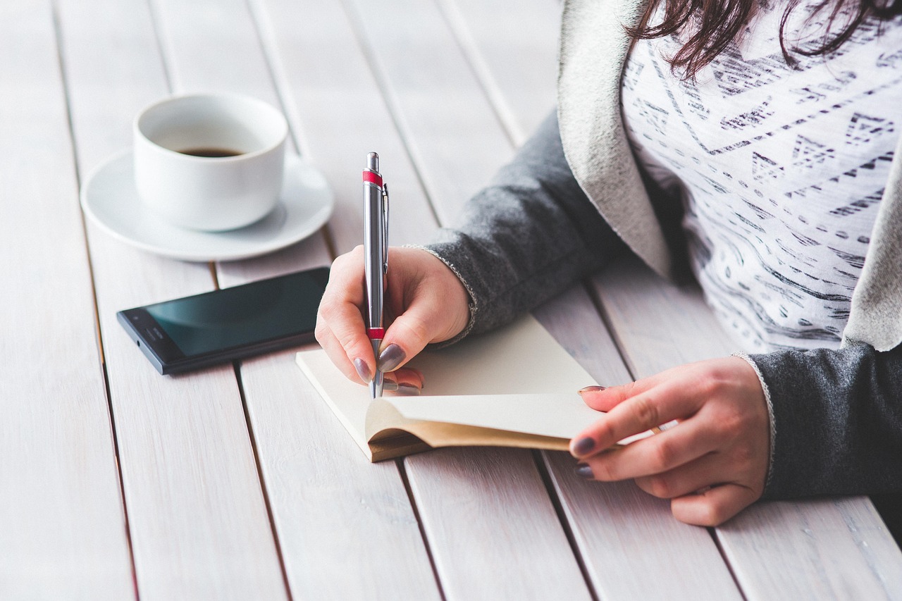 Woman, write, notepad — Managing Employee Safety During Business Trips